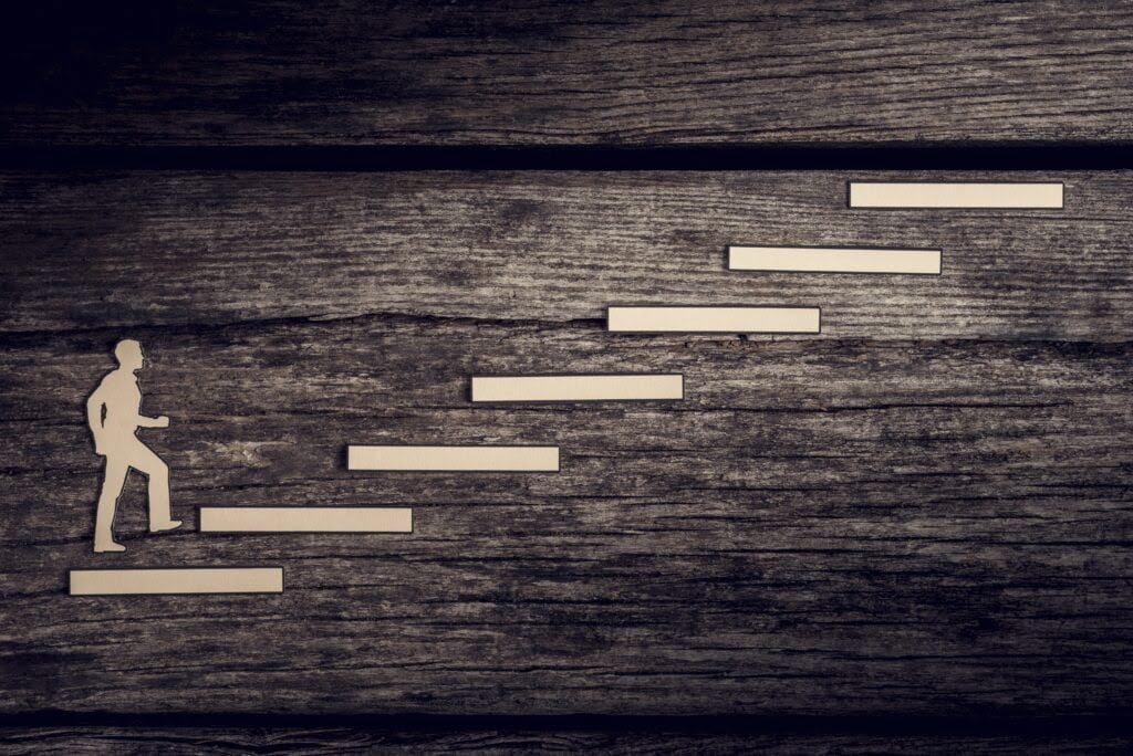 Mann, der Stufen heraufsteigt, um seine Ziele zu erreichen.